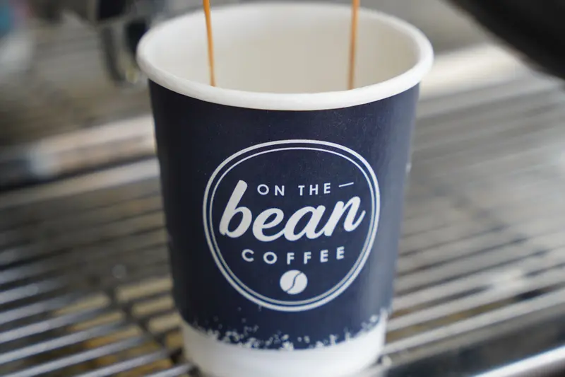 Espresso pouring into an On the Bean cup